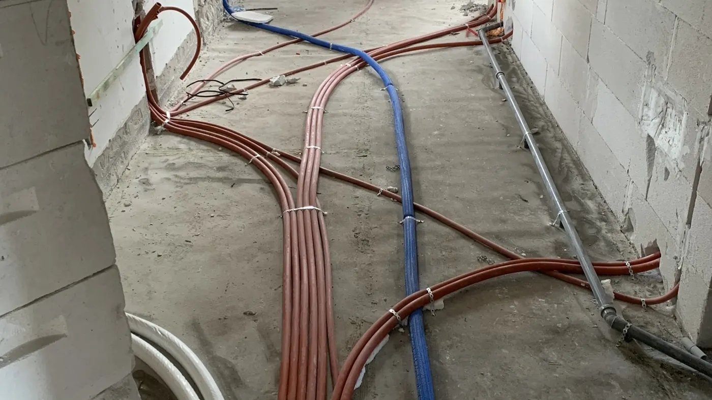 Védőcsőbe húzott vezetékek a betonaljzatban, új építésű háznál